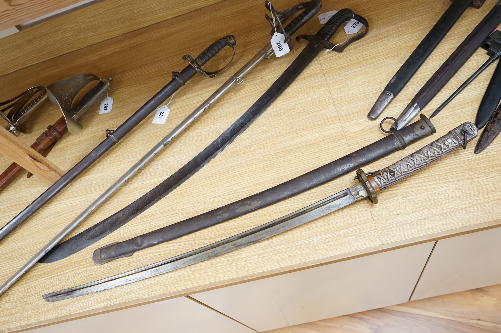 A Japanese World War II NCO‘s sword katana, regulation blade with fuller, stamped 33271, regulation aluminium hilt, brass guard, the spring catch still retains, in an iron scabbard